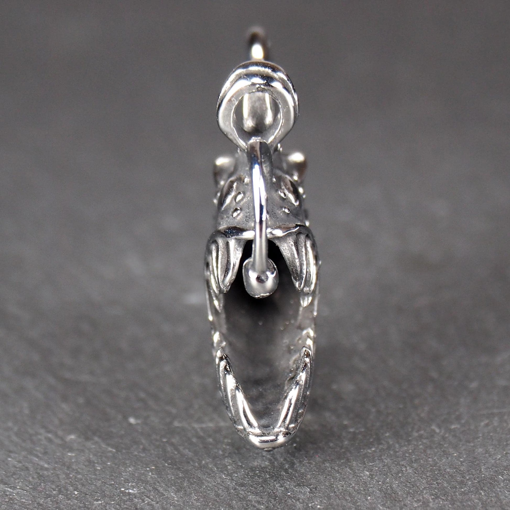 3D-Anhänger Anglerfisch, silberglänzend, mit geöffnetem Maul und dolchartigen Zähnen, geriffelten Flossen, punktiertem Körper und Öse.