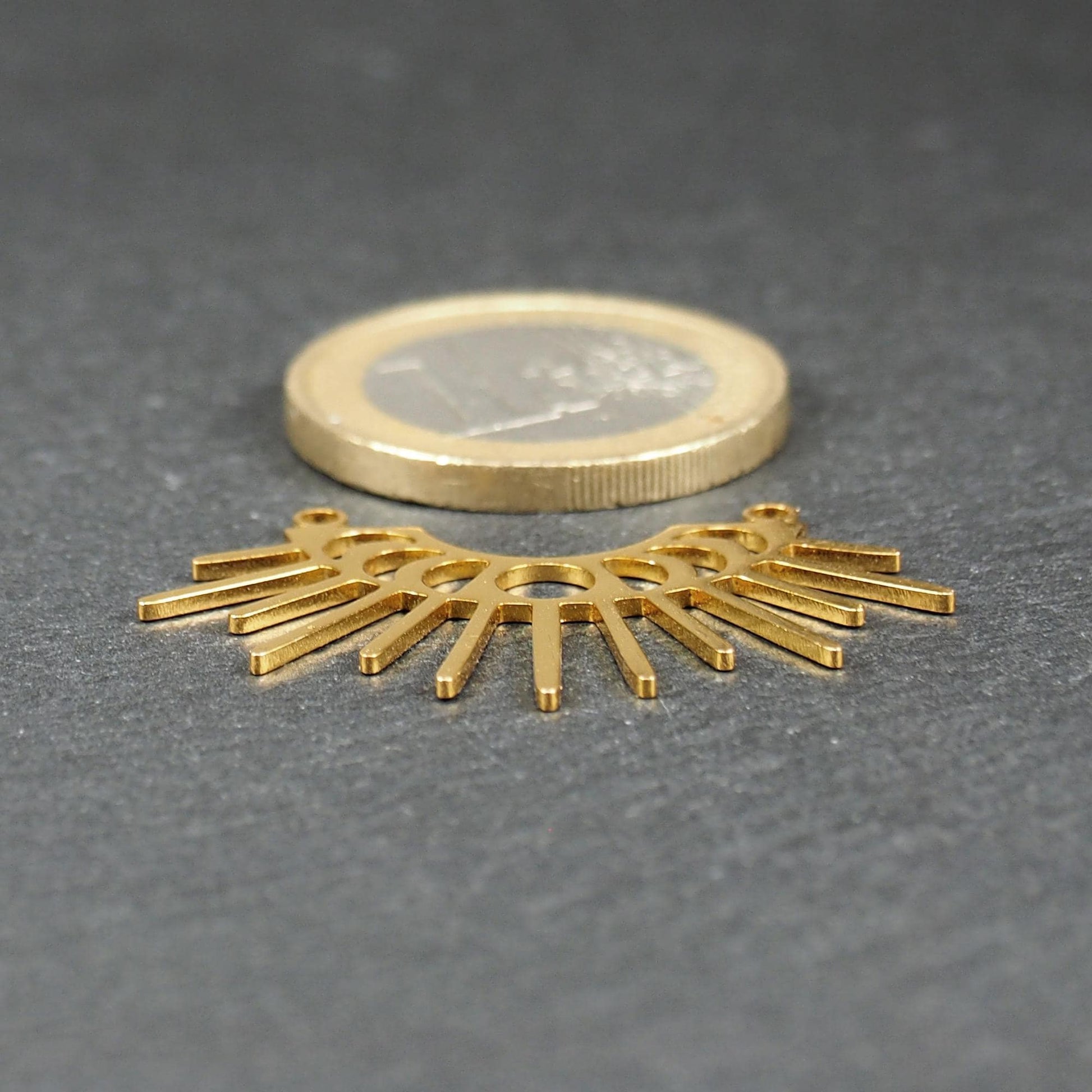 Verbinder, goldfarben glänzend, halbkreisförmig mit durchbrochenen Mondphasen und ausstrahlenden Sonnenstrahlen, oben zwei Ösen.