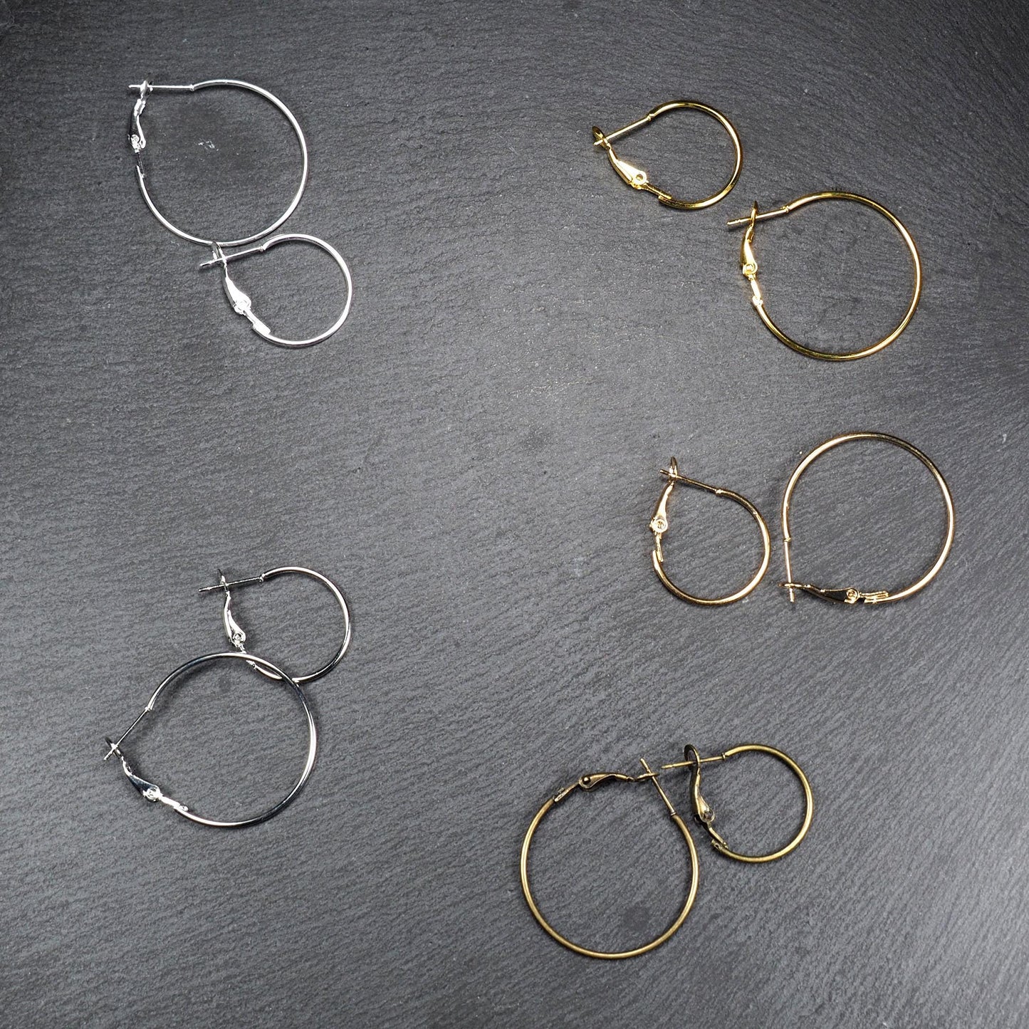 Runde Klapp-Creolen in silber, platin, hellgold, gelbgold und bronze mit Klappverschluss und glatter, glänzender Oberfläche, jeweils in zwei Größen.
