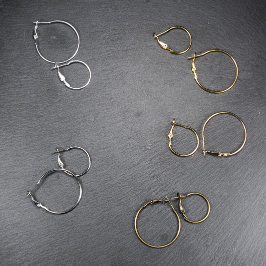 Runde Klapp-Creolen in silber, platin, hellgold, gelbgold und bronze mit Klappverschluss und glatter, glänzender Oberfläche, jeweils in zwei Größen.