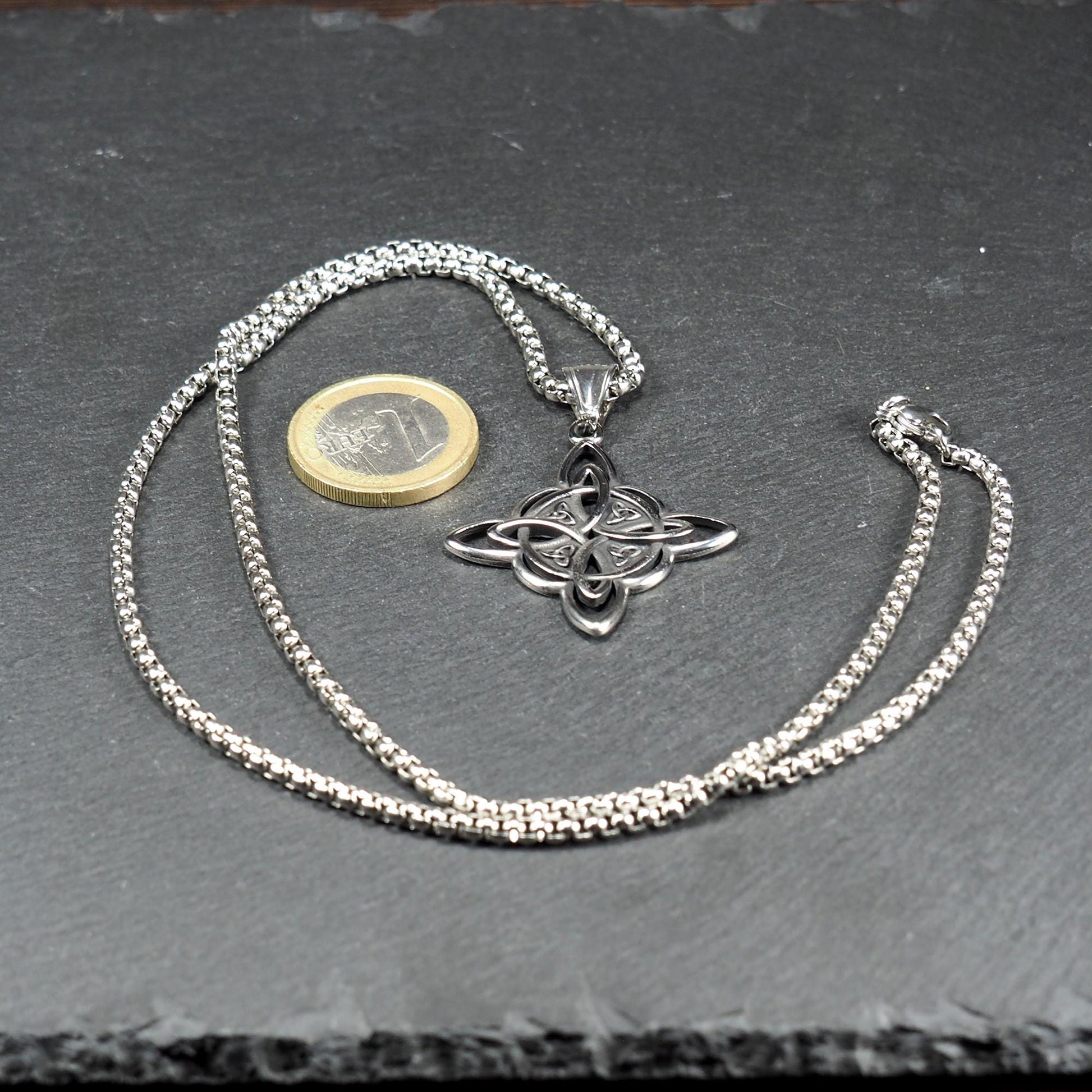 Silberfarbener, glänzender keltischer Knoten-Anhänger in Durchbruchoptik mit integrierter Öse an Boxkette mit Karabiner; 1‑Euro‑Münze daneben.