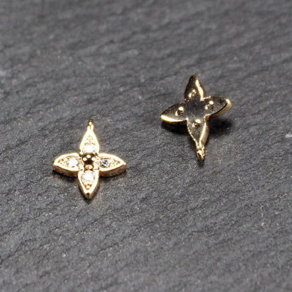 Zwei goldfarbene vierblättrige Blütenanhänger, Vorderseite mit vier eingelassenen Zirkonia und zentraler Kugel; Rückseite mit integrierter Öse.