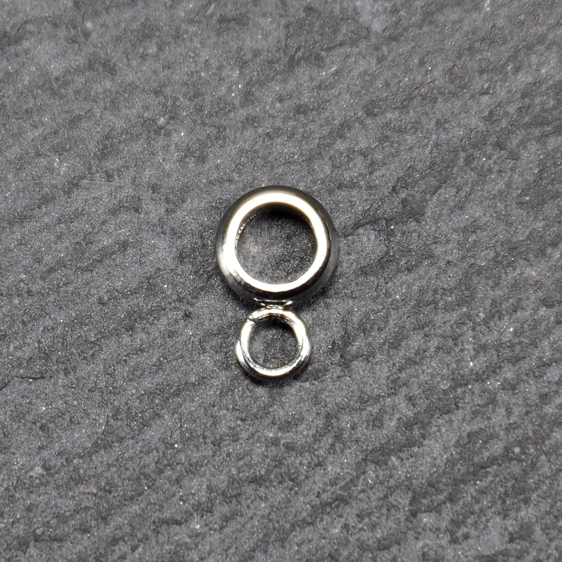 Runde Anhängeröse mit silberglänzender Oberfläche, kompakter durchbrochener Ring mit kleinem geschlossenen Ring unten.