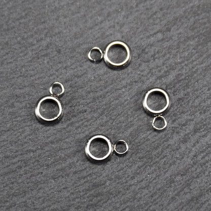 Vier glänzende silberfarbene runde Anhängerösen, jeweils ein größerer hohler Ring mit einer kleineren beweglichen Ringöse.