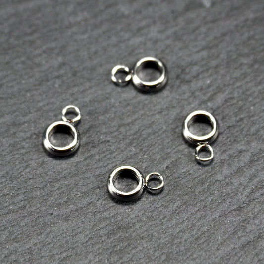 Vier glänzende silberfarbene runde Anhängerösen, jeweils ein größerer hohler Ring mit einer kleineren beweglichen Ringöse.