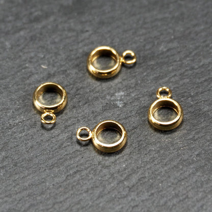Vier runde, goldfarbene glänzende Anhängerösen in Ringform mit durchbrochenem Innenraum und integrierter kleiner Öse.