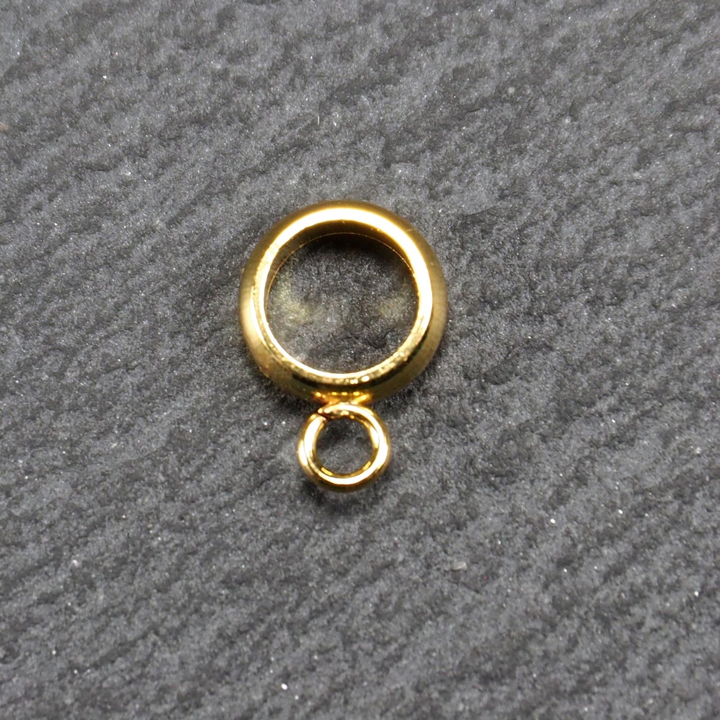 Runde, vergoldete Anhängeröse mit glänzender Oberfläche, offenes Ringdesign und integrierter kleiner Verbindungsöse.