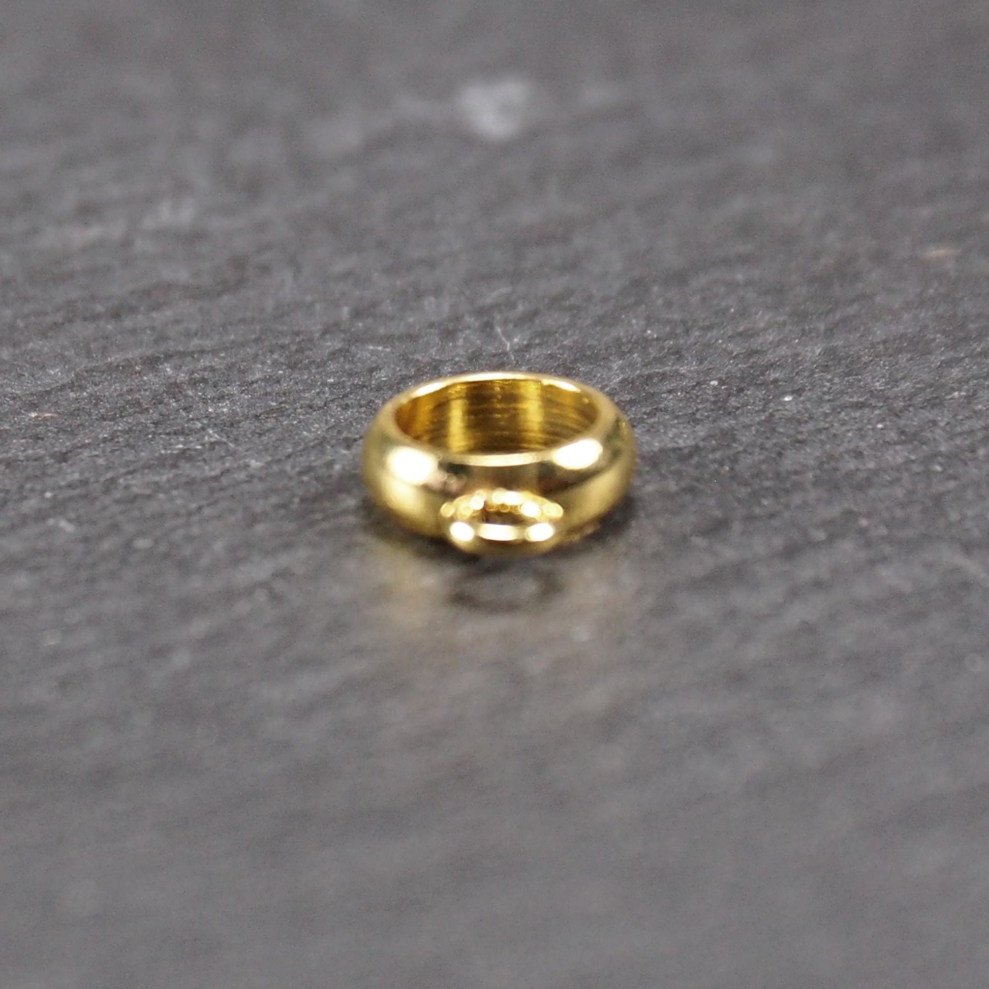 Runde, vergoldete Anhängeröse mit glänzender Oberfläche, offenes Ringdesign und integrierter kleiner Verbindungsöse.