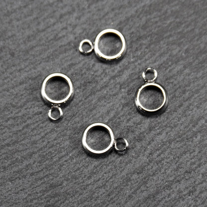 Vier runde, silberfarbene Anhängerösen mit glänzender Oberfläche: hohle Ringscheiben mit jeweils einer kleinen Öse.