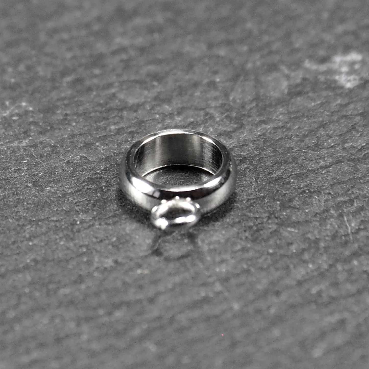 Runder, poliert glänzender silberfarbener Anhängerring mit großem Innenkreis und einer kleineren, unten befestigten Öse.