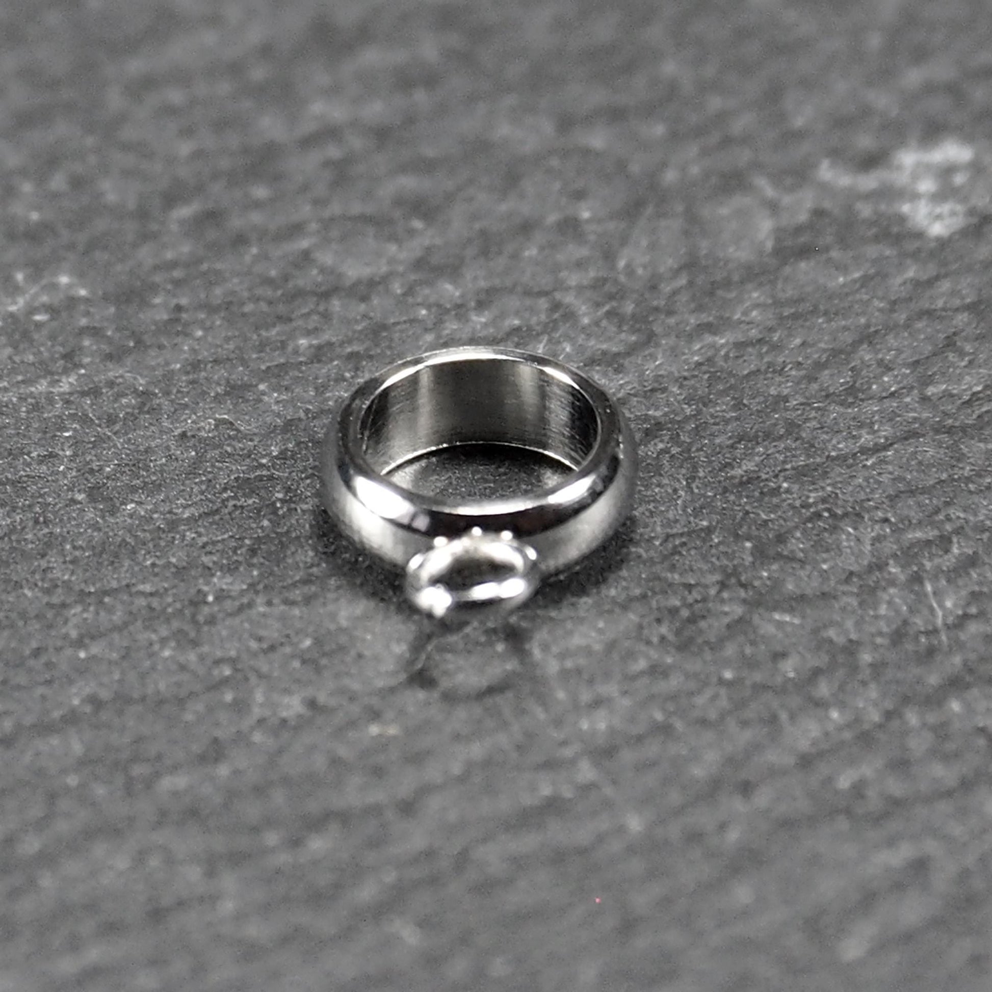 Runder, poliert glänzender silberfarbener Anhängerring mit großem Innenkreis und einer kleineren, unten befestigten Öse.