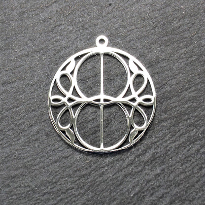 Runder, silberfarbener, polierter Anhänger mit filigranem, durchbrochenem Vesica-Piscis-/Mandorla-Motiv und integrierter Öse oben.