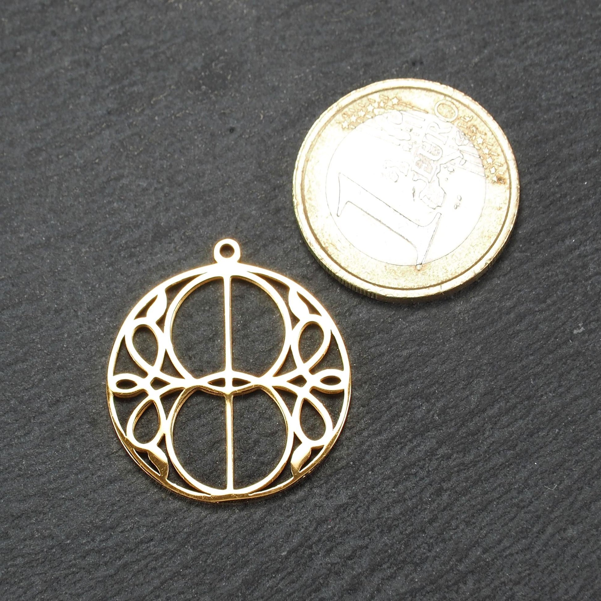 Runder, goldfarbener, filigran durchbrochener Anhänger mit symmetrischem Vesica-Piscis-Ornament und kleiner Öse oben.