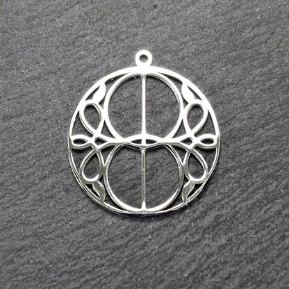 Runder, silberfarbener, polierter Anhänger mit filigranem, durchbrochenem Vesica-Piscis-/Mandorla-Motiv und integrierter Öse oben.
