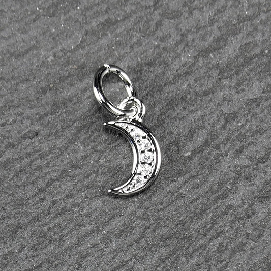 Mondsichel-Anhänger, silberfarben und poliert, ist mit fünf kleinen klaren Steinen entlang der Innenkante und einer ovalen Öse oben.