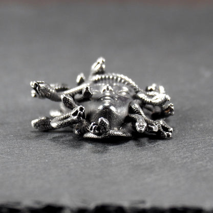 Silberfarbener, dreidimensionaler und glänzender Medusa-Anhänger in Relief mit menschlichem Gesicht und vielen schlangenförmigen Haaren, sichtbarer Öse.