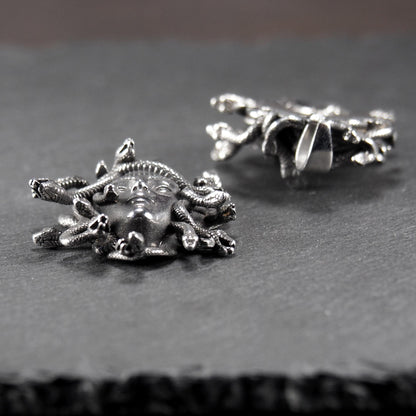 Silberfarbener, dreidimensionaler und glänzender Medusa-Anhänger in Relief mit menschlichem Gesicht und vielen schlangenförmigen Haaren, sichtbarer Öse.