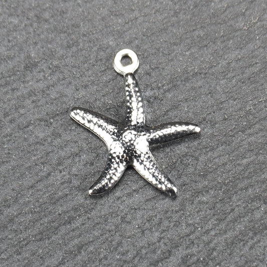 Seestern-Anhänger aus silberfarbenem Metall mit reliefartiger, strukturierter glänzender Oberfläche, fünf Armen und kleiner runder Öse oben.