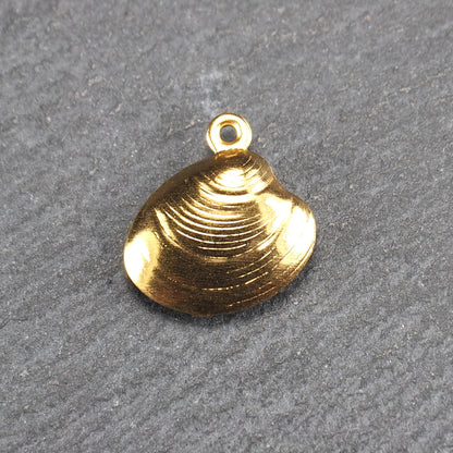 Kleiner muschelförmiger Anhänger, goldfarbene glänzende Oberfläche mit konzentrischen Rillen und integrierter Öse oben.