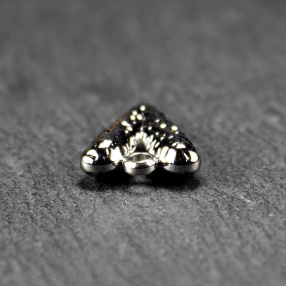 Herzanhänger, silberfarbig hochglänzend mit reliefartiger Oberfläche, spitz zulaufender Unterseite und integrierter runder Öse.