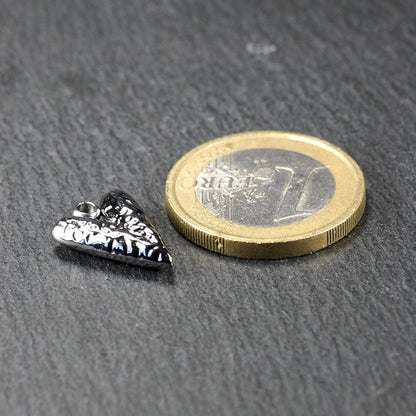 Silberner, hochglanzpolierter herzförmiger Anhänger mit reliefartiger Oberfläche und integrierter Öse, neben einer Ein-Euro-Münze zur Größendarstellung.