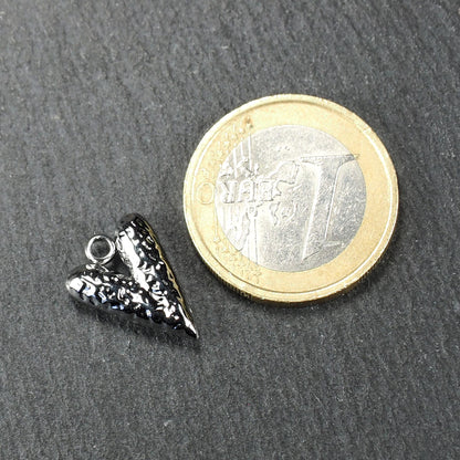 Silberner, hochglanzpolierter herzförmiger Anhänger mit reliefartiger Oberfläche und integrierter Öse, neben einer Ein-Euro-Münze zur Größendarstellung.