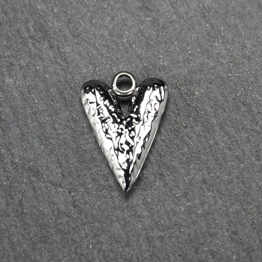 Herzanhänger, silberfarbig hochglänzend mit reliefartiger Oberfläche, spitz zulaufender Unterseite und integrierter runder Öse.