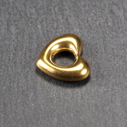 Herzförmiger, goldfarbener Anhänger mit hochglänzender, glatter Oberfläche, rundem durchbrochenem Zentrum und sichtbarer Bohrung.