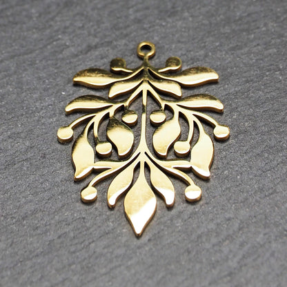 Goldfarbener Metallanhänger mit glänzender Oberfläche, durchbrochenes Zweig- und Beerenmotiv mit stilisierten Blättern und runder Öse oben.