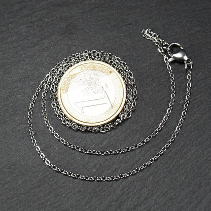 Eine Ankerkette hat filigrane offene Ankerglieder, polierte silberne Oberfläche und einen sichtbaren Karabinerverschluss.