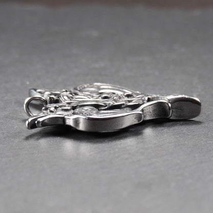 Anhänger aus poliertem silberfarbenem Edelstahl, zweiköpfiges, spitz zulaufendes Rabenschwert Ornament mit Relief, Durchbrüchen und sichtbarer Öse.