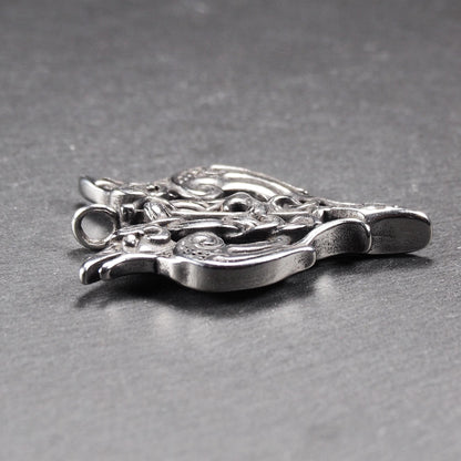 Anhänger aus poliertem silberfarbenem Edelstahl, zweiköpfiges, spitz zulaufendes Rabenschwert Ornament mit Relief, Durchbrüchen und sichtbarer Öse.