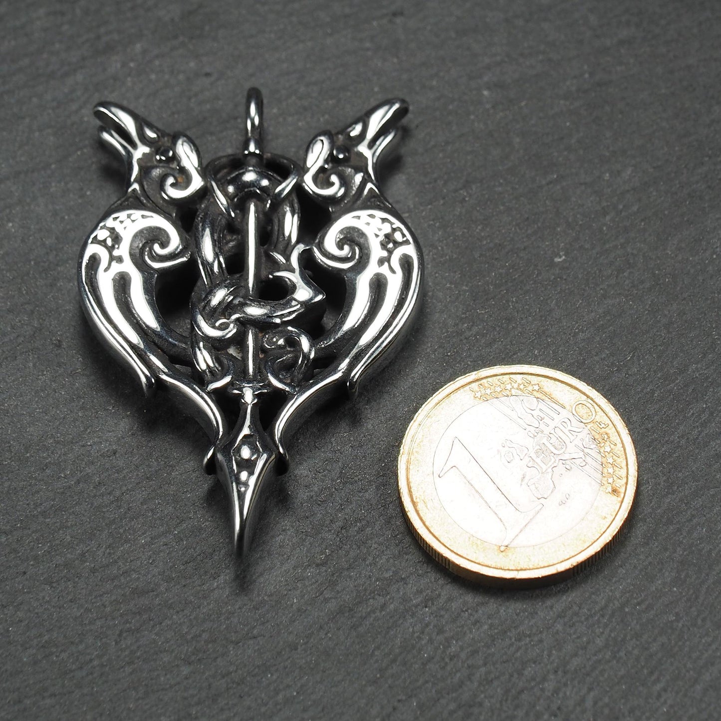 Anhänger aus poliertem silberfarbenem Edelstahl, zweiköpfiges, spitz zulaufendes Rabenschwert Ornament mit Relief, Durchbrüchen und sichtbarer Öse.