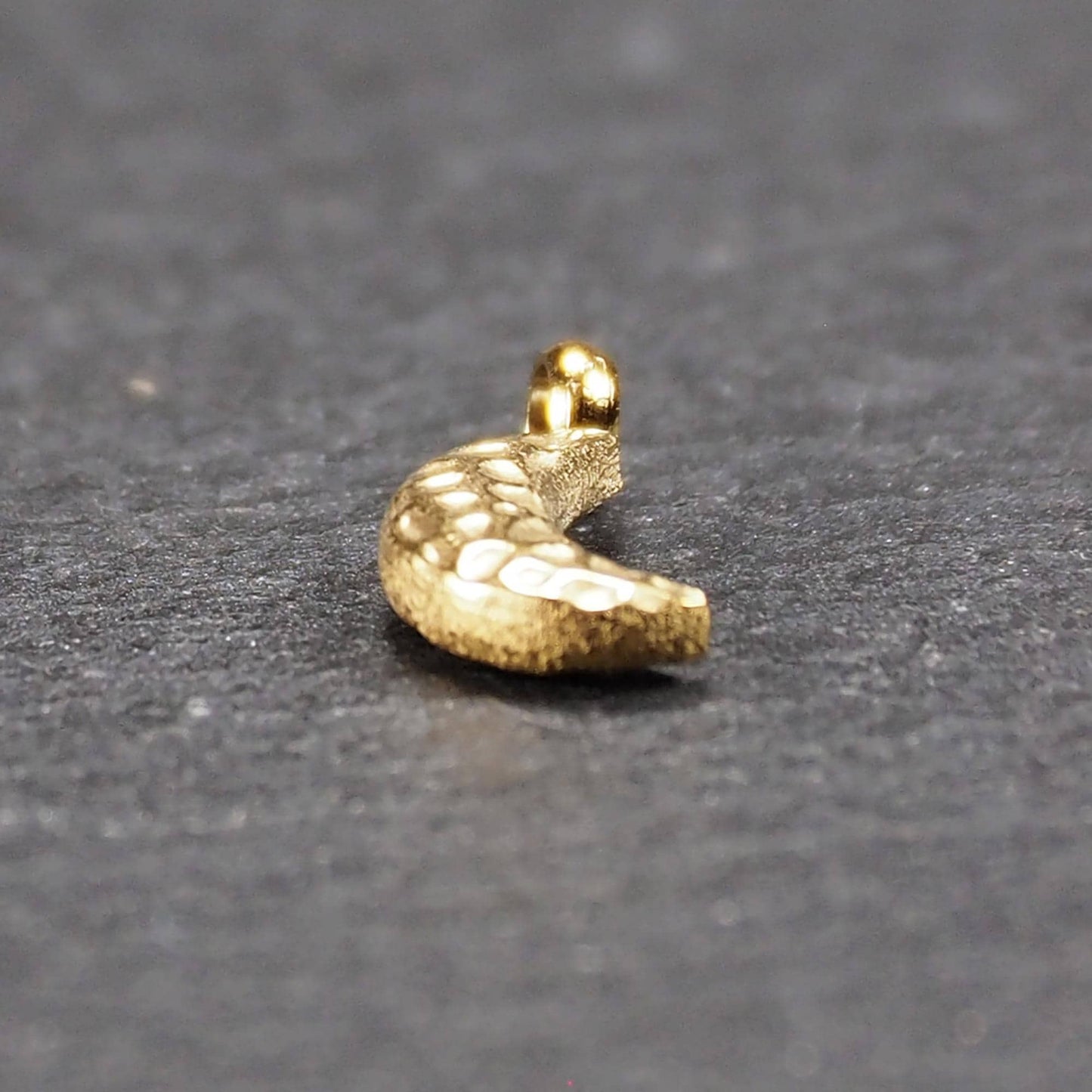 Halbmond-Anhänger, goldfarben und glänzend, reliefartige gehämmerte Textur, organisch geschwungene Mondsichelform mit kleiner Öse oben.