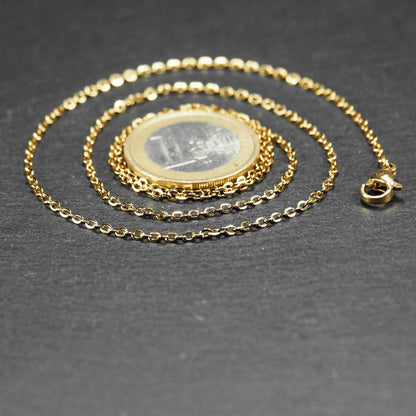 Feine goldfarbene Ankerkette mit glänzender Oberfläche, filigranen ovalen Gliedern in Spiralform und sichtbarem Karabinerverschluss.