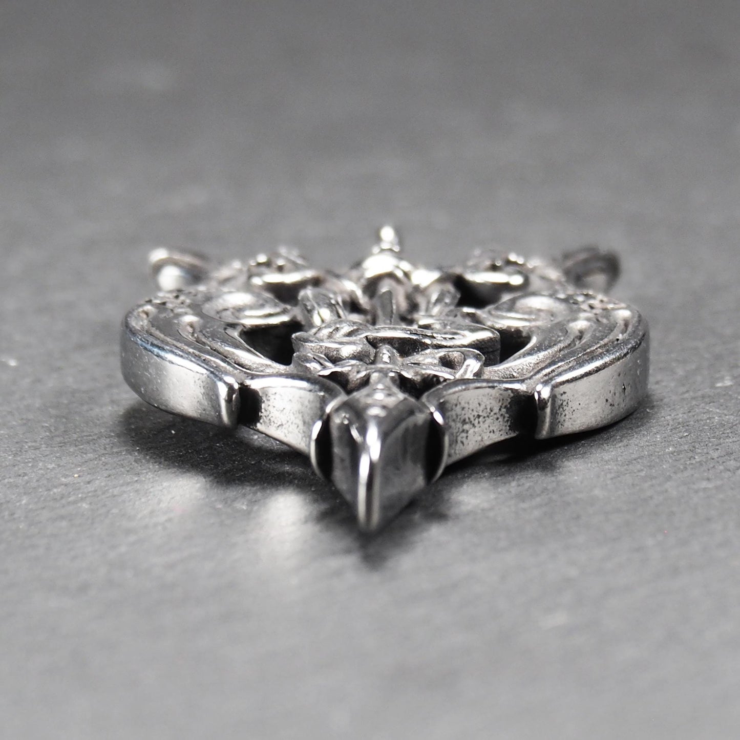 Anhänger aus poliertem silberfarbenem Edelstahl, zweiköpfiges, spitz zulaufendes Rabenschwert Ornament mit Relief, Durchbrüchen und sichtbarer Öse.