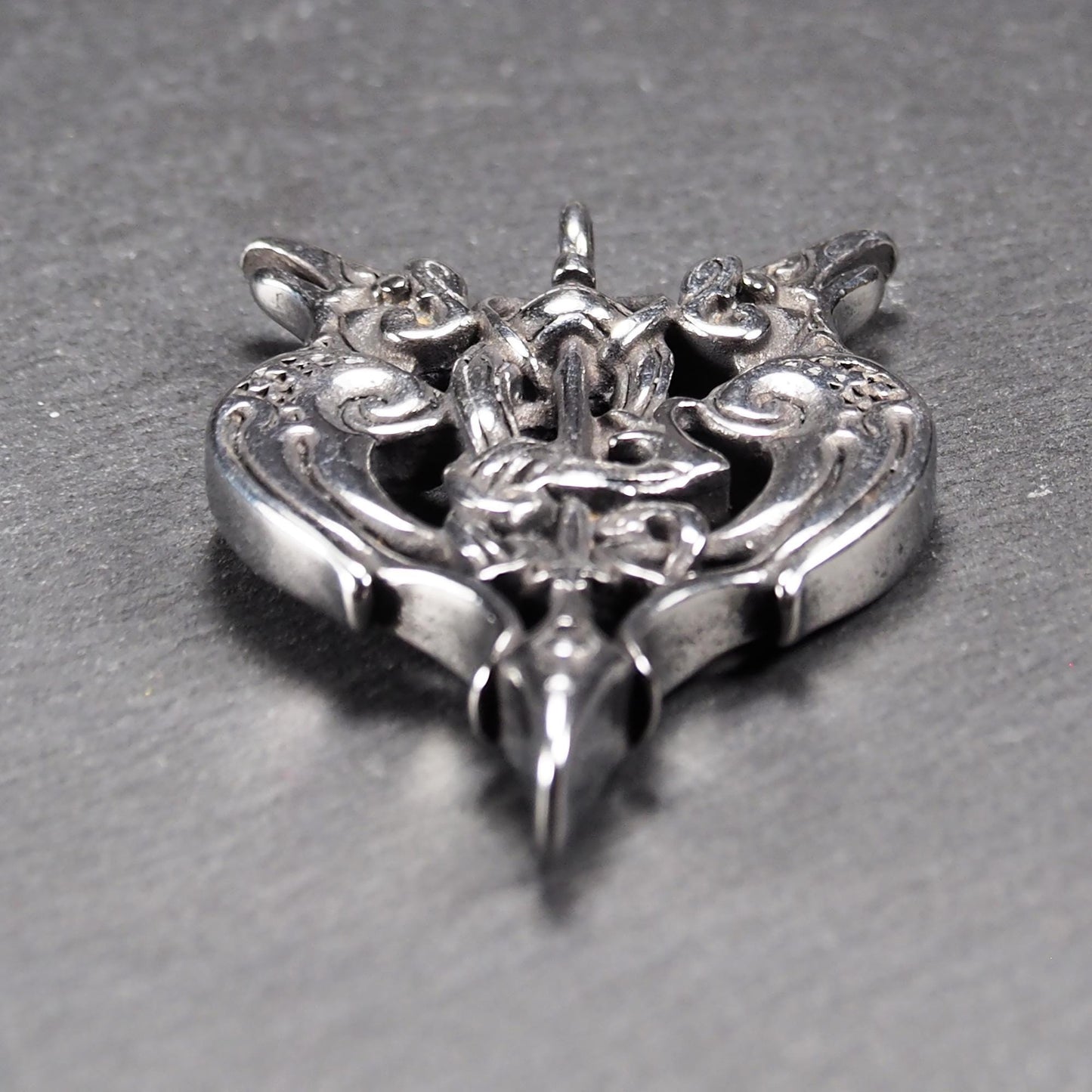 Anhänger aus poliertem silberfarbenem Edelstahl, zweiköpfiges, spitz zulaufendes Rabenschwert Ornament mit Relief, Durchbrüchen und sichtbarer Öse.