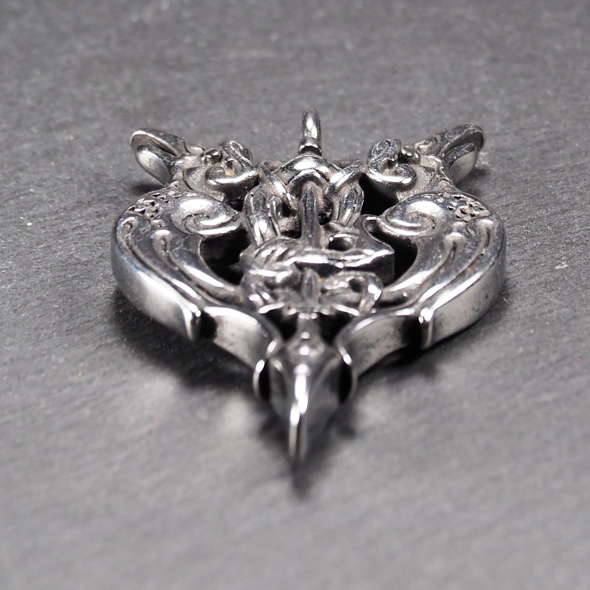 Anhänger aus poliertem silberfarbenem Edelstahl, zweiköpfiges, spitz zulaufendes Rabenschwert Ornament mit Relief, Durchbrüchen und sichtbarer Öse.