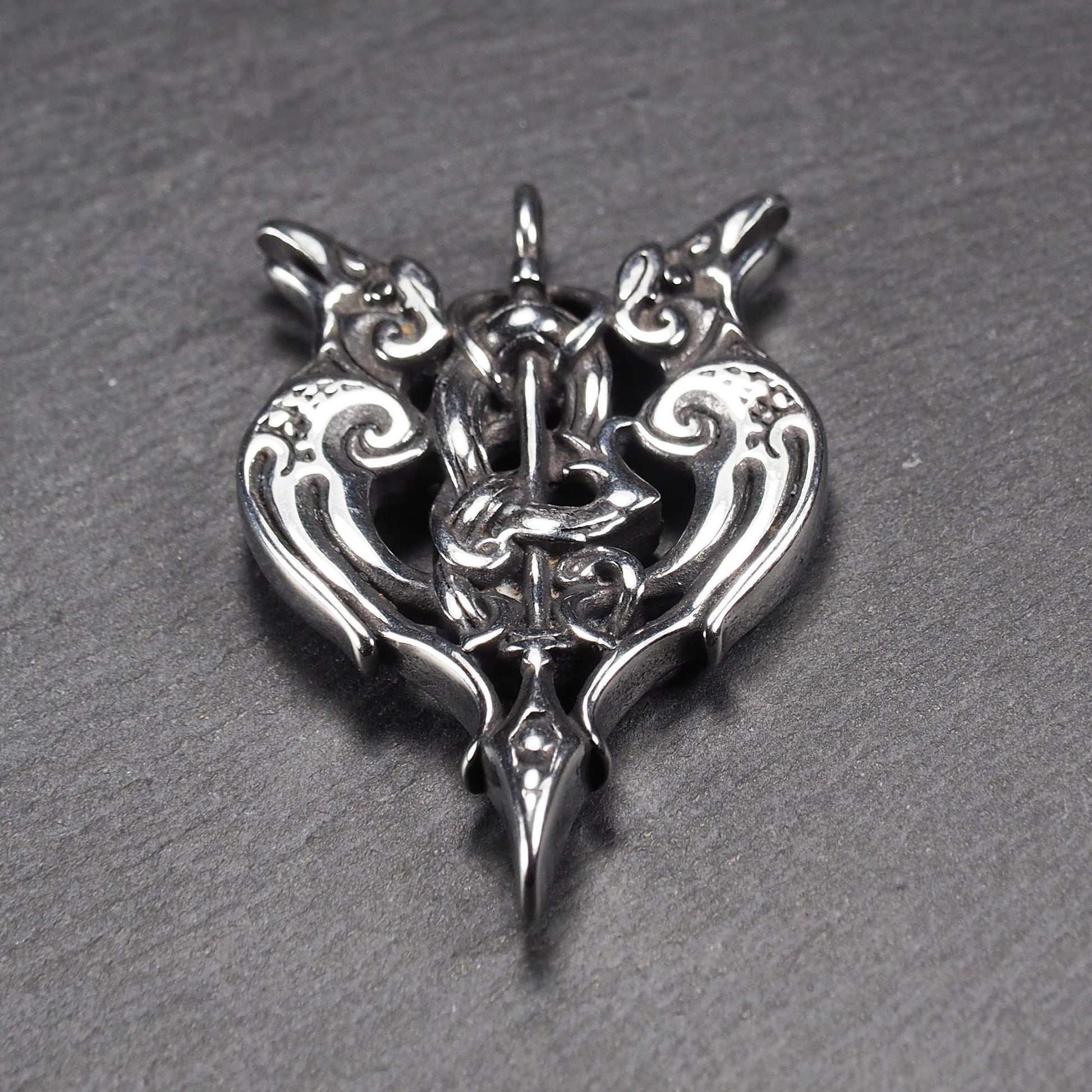 Anhänger aus poliertem silberfarbenem Edelstahl, zweiköpfiges, spitz zulaufendes Rabenschwert Ornament mit Relief, Durchbrüchen und sichtbarer Öse.