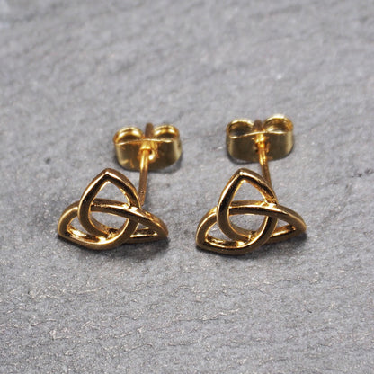 Paar goldfarbener Ohrstecker mit offen gearbeitetem Triquetra-Knoten, glänzende Oberfläche und sichtbaren Schmetterlingsverschlüssen.