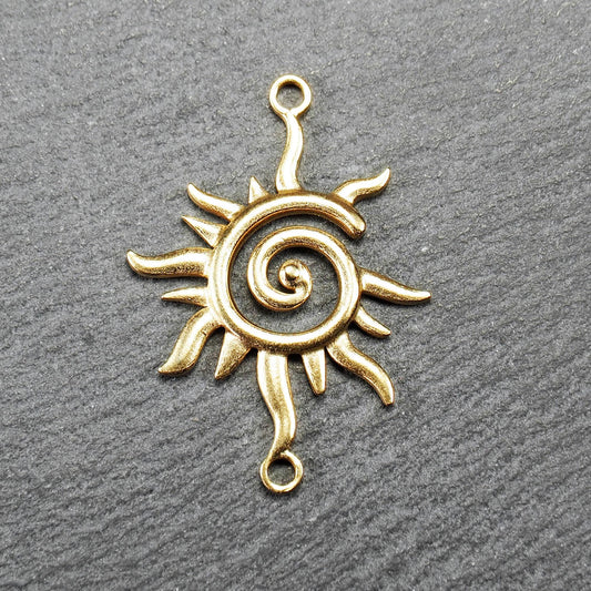 Goldfarbener, durchbrochener Sonnen-Verbinder mit spiralförmigem Zentrum, unregelmäßigen wellenförmigen Strahlen und je einer Öse oben und unten.