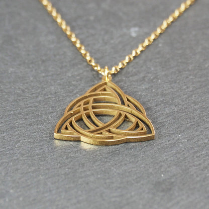 Vergoldeter Anhänger in offener Triquetra-Knotenform mit filigranen Durchbrüchen, an dünner goldfarbener Kette und sichtbarer Öse.