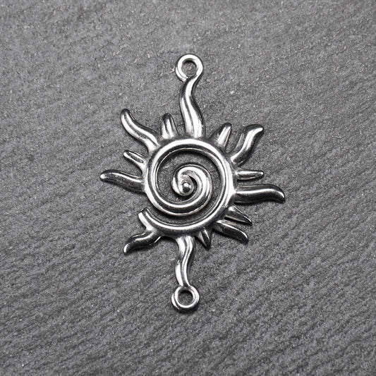 Sonnenförmiger silberner Verbinder mit glänzender Oberfläche, spiralförmigem Durchbruchzentrum, reliefartigen flammenförmigen Strahlen und zwei Ösen.