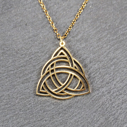 Vergoldeter Anhänger in offener Triquetra-Knotenform mit filigranen Durchbrüchen, an dünner goldfarbener Kette und sichtbarer Öse.