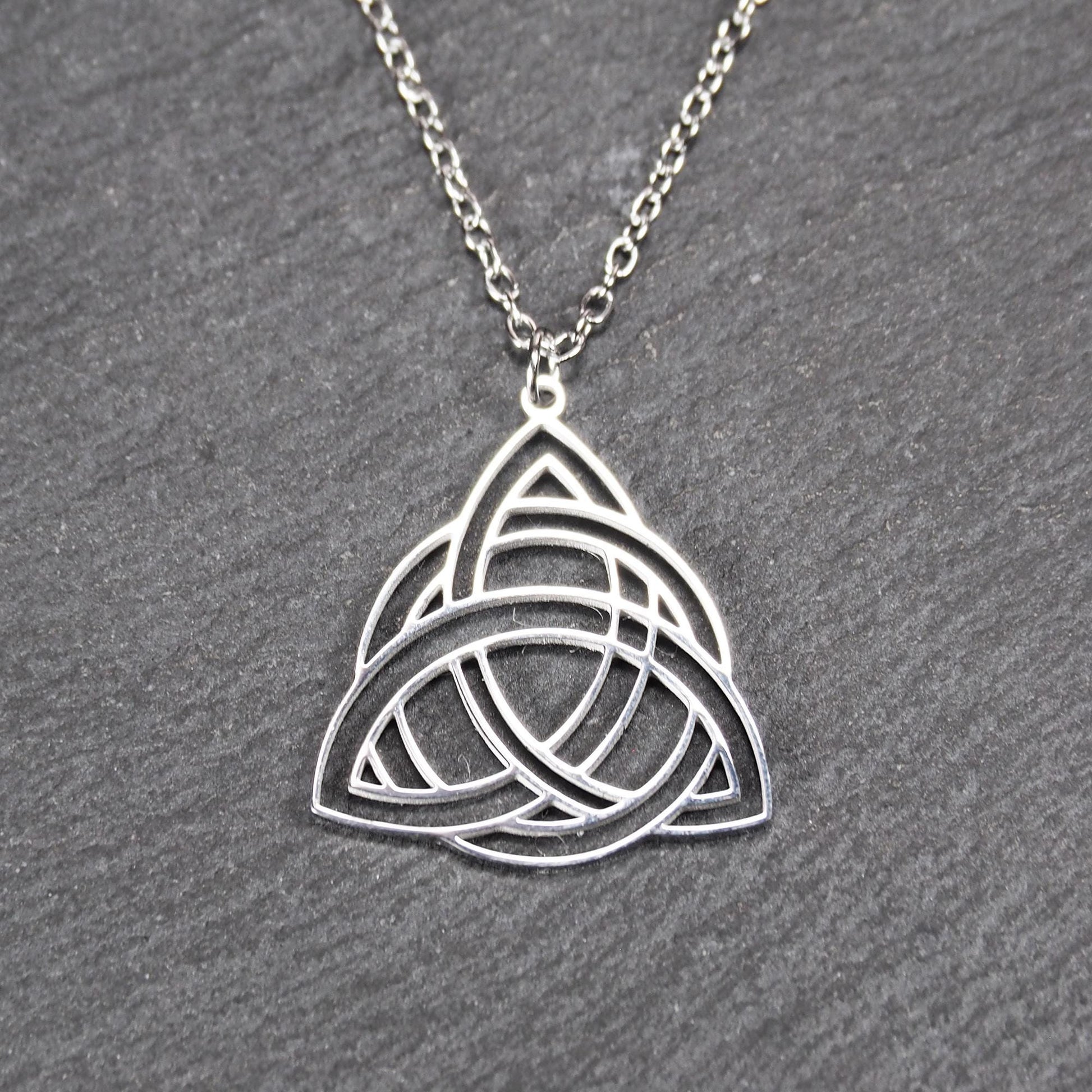 Anhänger, silberfarben glänzend; dreieckige, offene Triquetra-Knotenform mit filigraner Durchbruchstruktur und sichtbarer Öse an feiner Gliederkette.