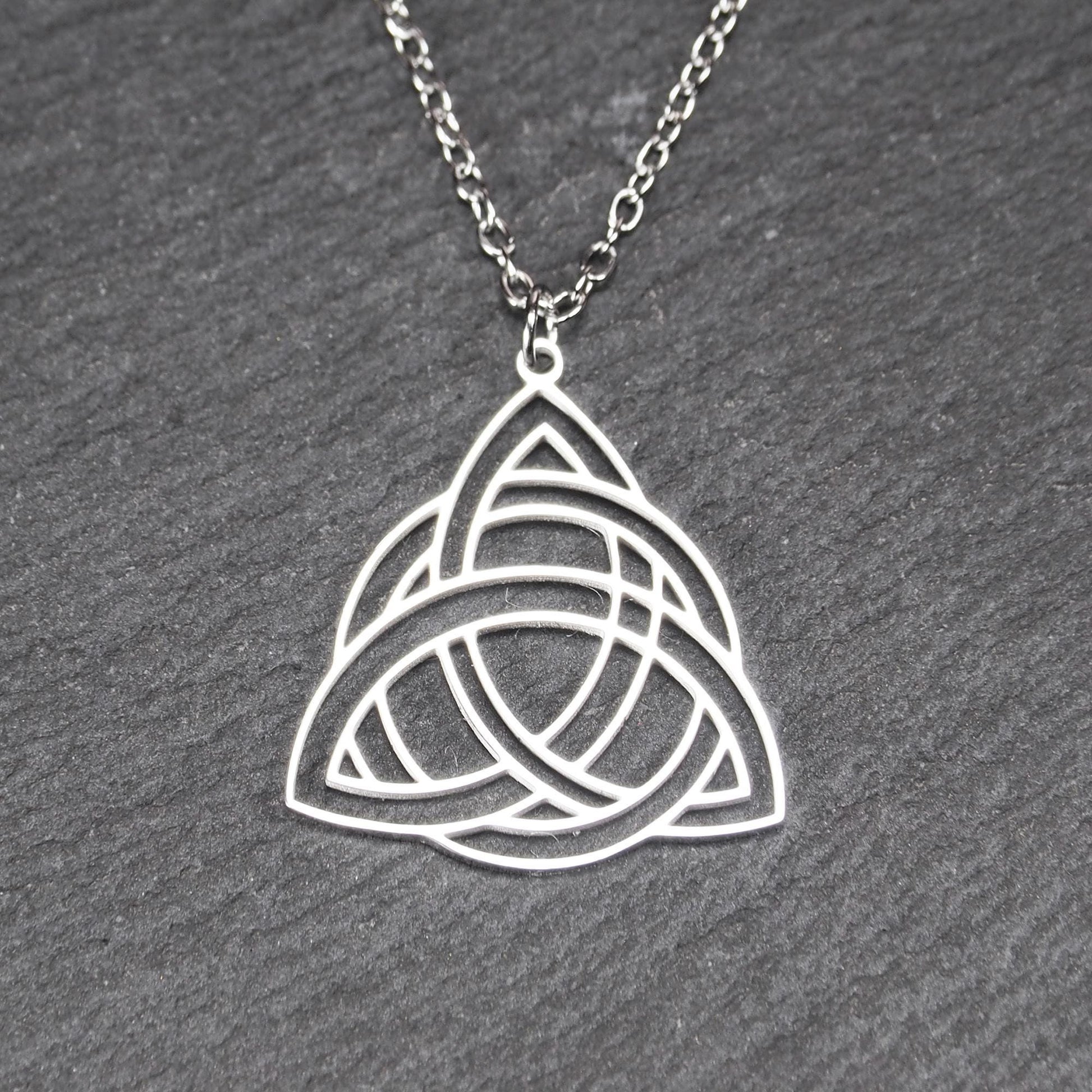 Anhänger, silberfarben glänzend; dreieckige, offene Triquetra-Knotenform mit filigraner Durchbruchstruktur und sichtbarer Öse an feiner Gliederkette.